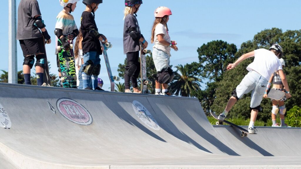 Young skateboarders wearing helmets and pads during a Surely Skate community session