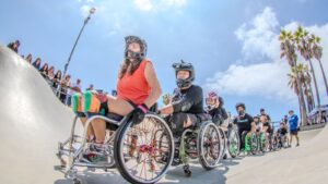 Adaptive wheelchair skaters lined up inside Venice Skate Park during a Life Rolls On event
