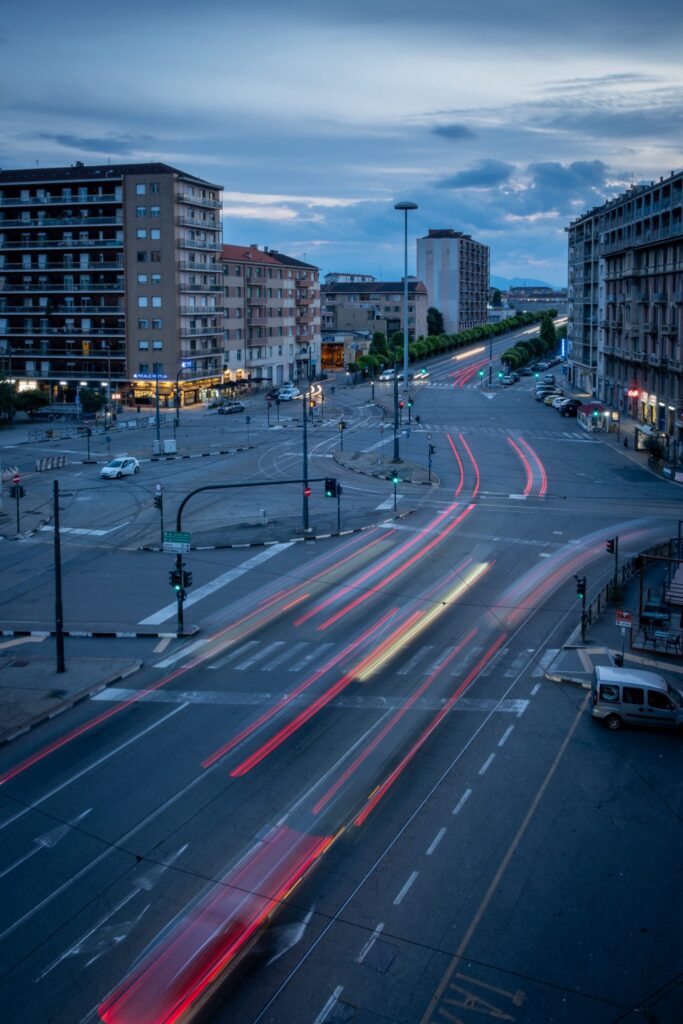 A long exposure photo of a busy intersection in the evening, with light trails from passing vehicles, taken from an elevated position. — Photo by Roy Tanck